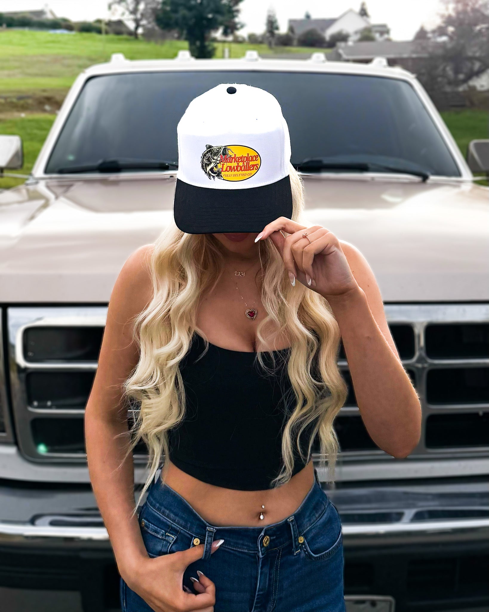 Woman wearing a cap with a logo in front of a truck