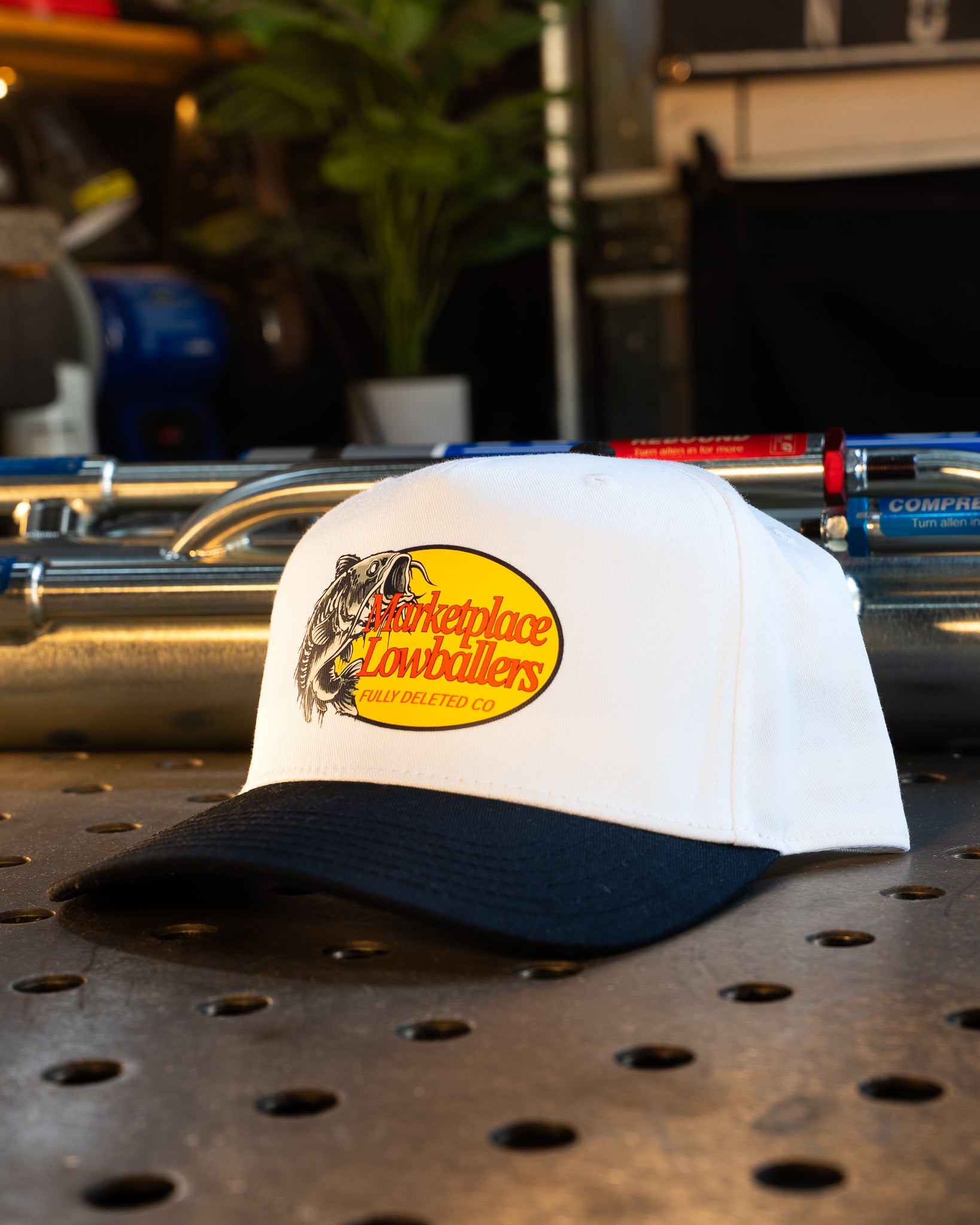 White cap with a yellow logo on a metal surface