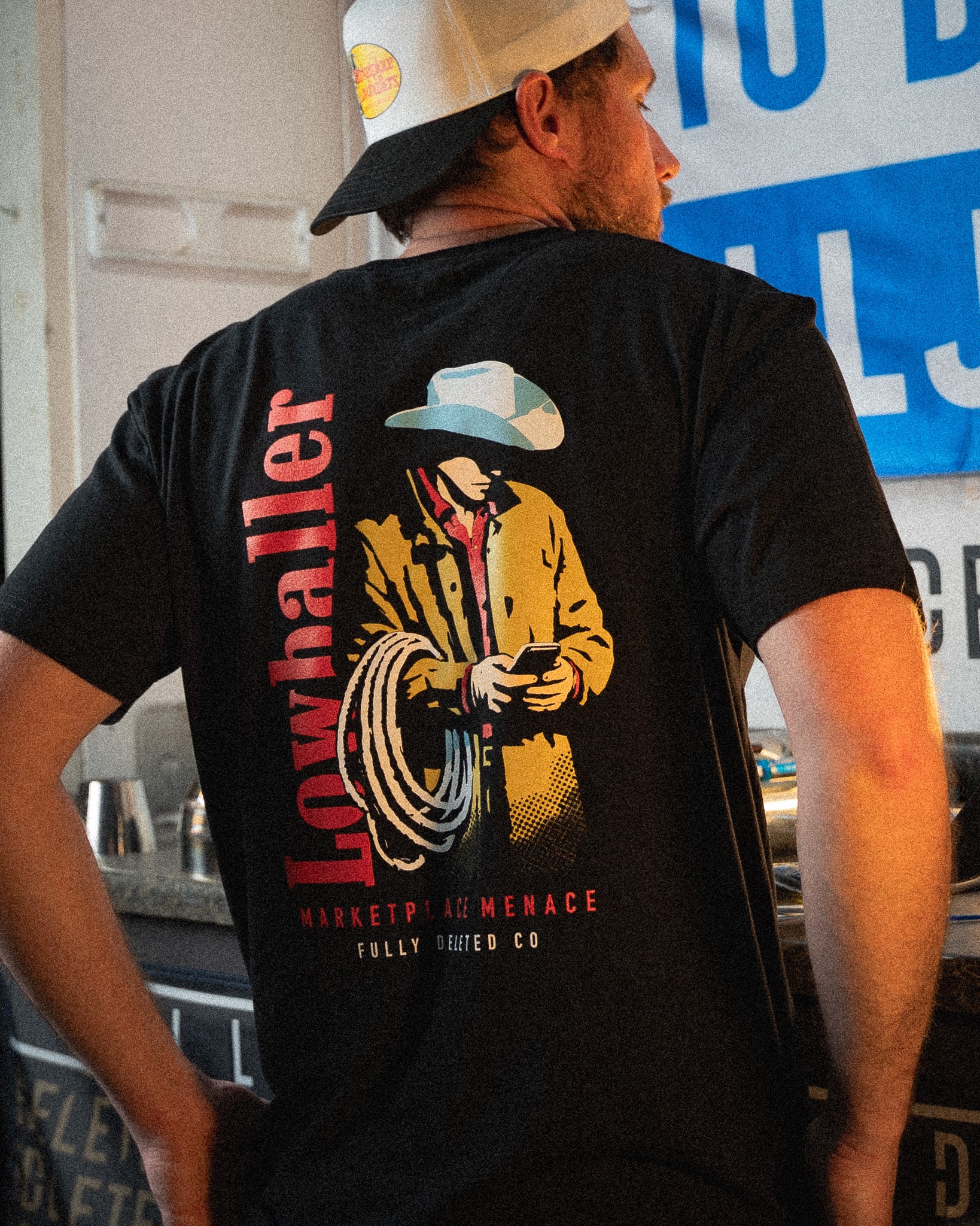 Person wearing a black t-shirt with a graphic design and text, standing indoors.