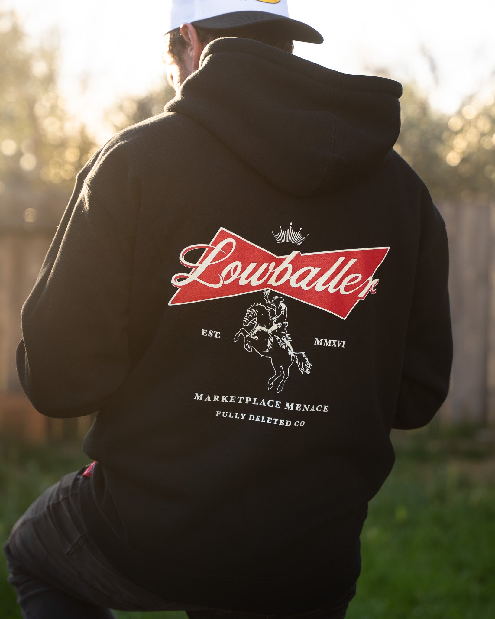 Person wearing a black hoodie with 'Lowballer' logo outdoors